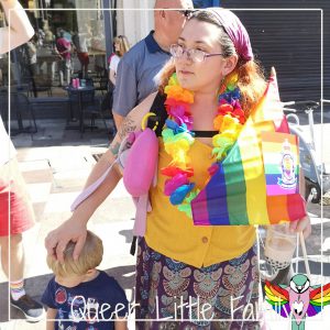 Bethend at the parade, with a rainbow lei and Pride flag.
