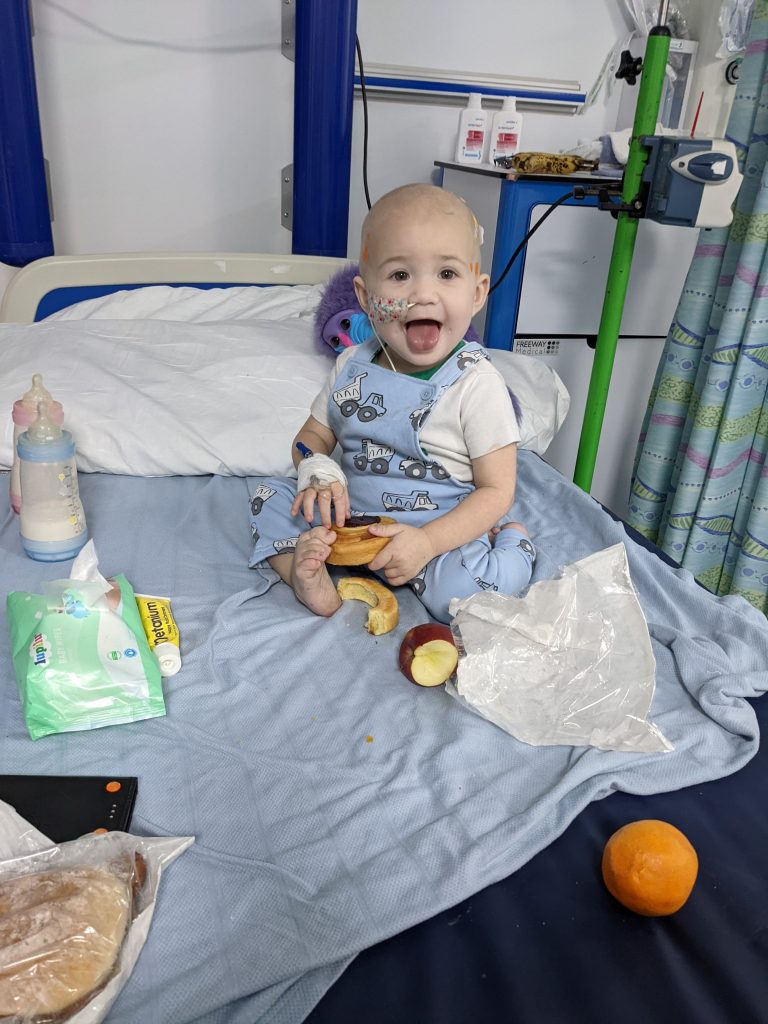 A smiling toddler in a hospital bed